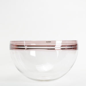 Clear glass bowl with mauve rim on a white background