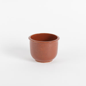 Dark orange ceramic cup on a white background