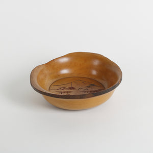 Wooden bowl with engraved design on a white background