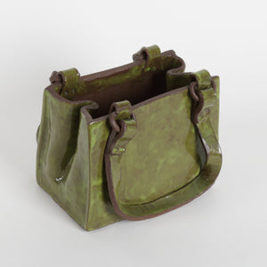 Green ceramic bag with brown accents on a white background