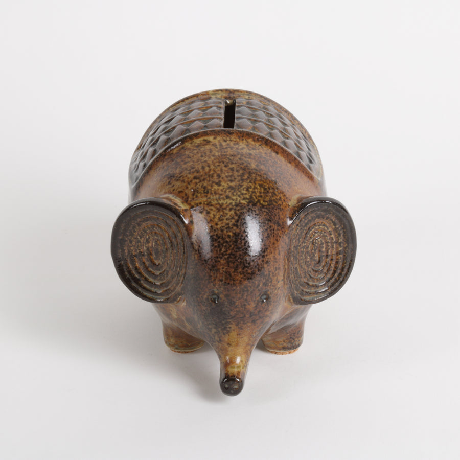 Brown ceramic elephant piggy bank with textured design on a white background