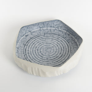Hexagonal ceramic dish with blue textured top and white base on a light gray background