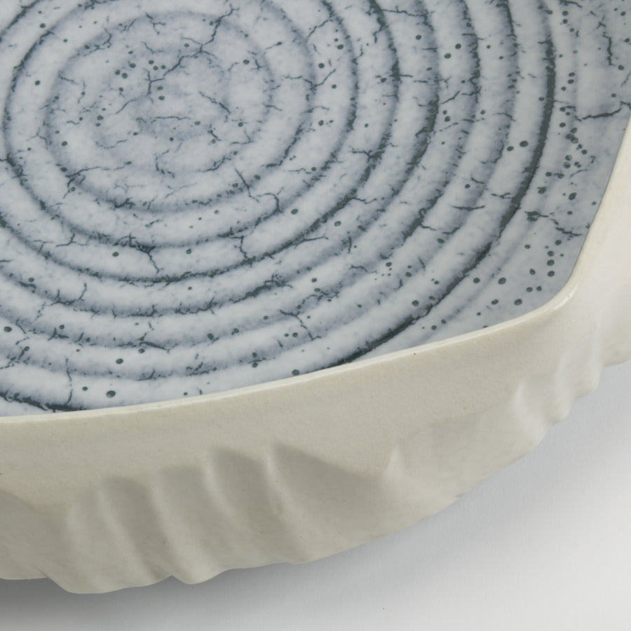 Hexagonal ceramic dish with blue textured top and white base on a light gray background