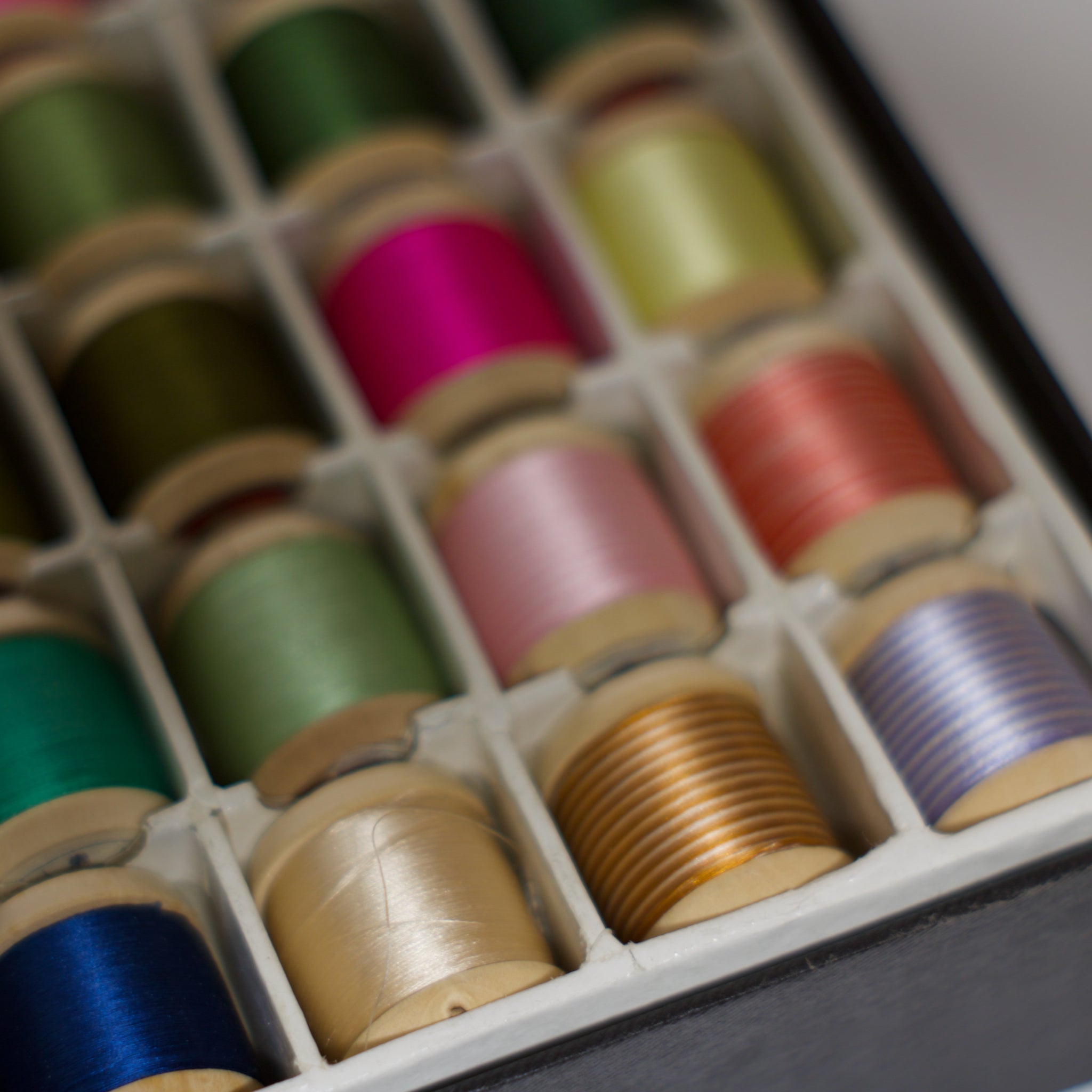 Set of colorful spools of thread in a box