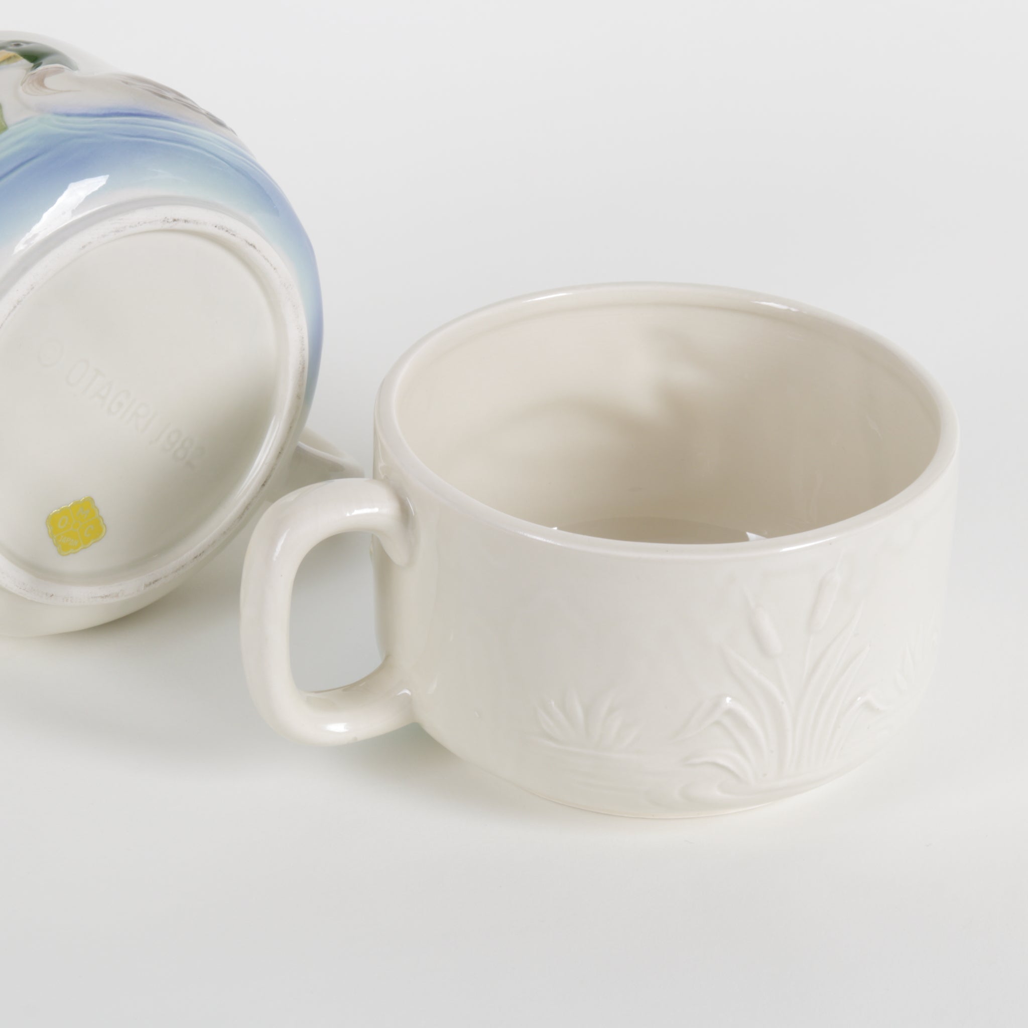White ceramic cup with floral patterns on a light gray background