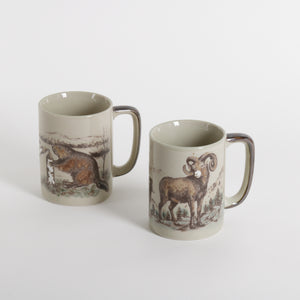 ceramic mugs with artistic scenes of ram sheep and beavers photographed against a white background