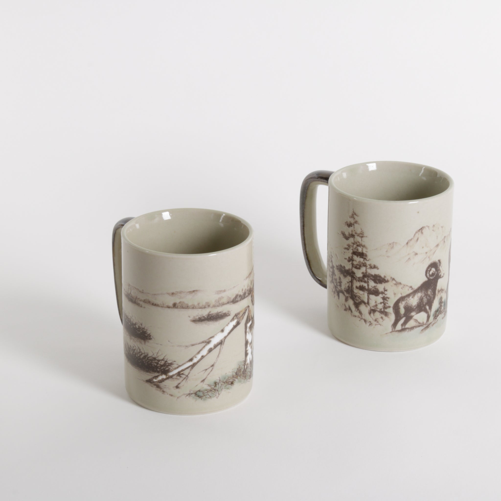 Two ceramic tea or coffee mugs with nature scenes, trees and ram sheep