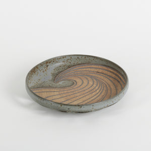 Ceramic dish with wavy design on a white background