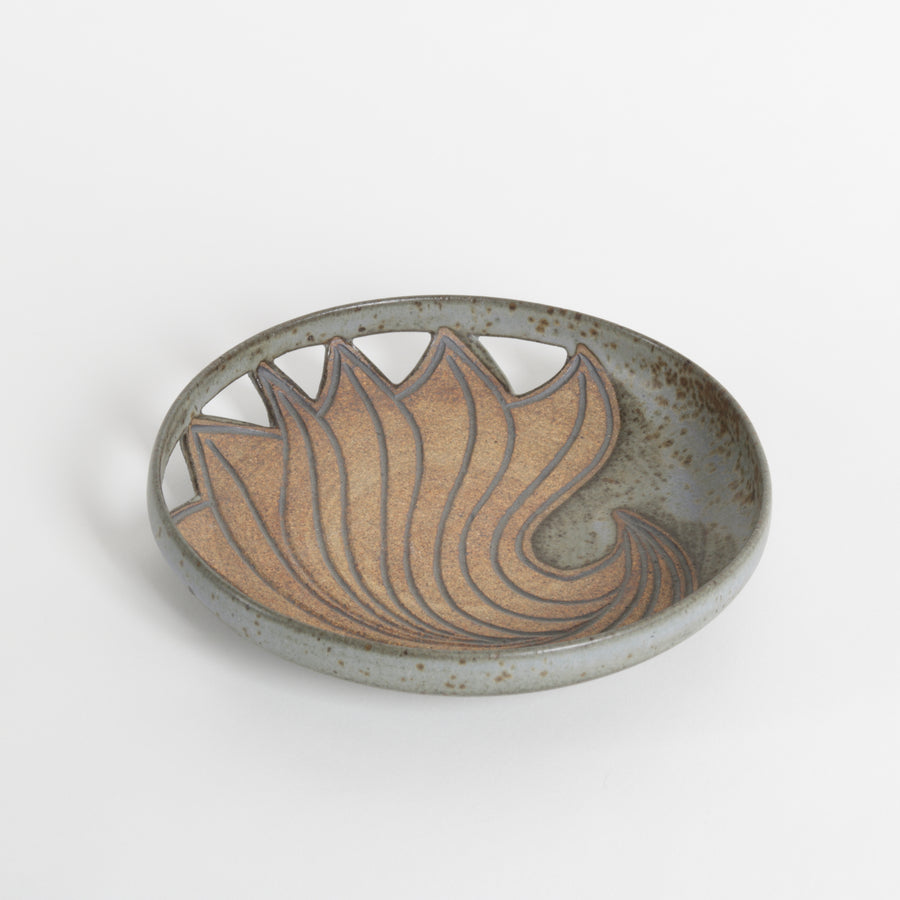 Ceramic dish with wavy design on a white background
