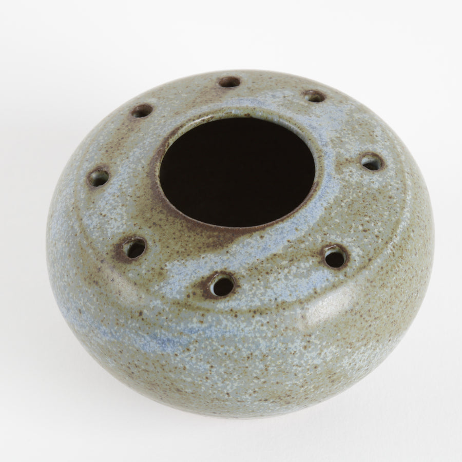 Small ceramic vase with textured surface on a white background