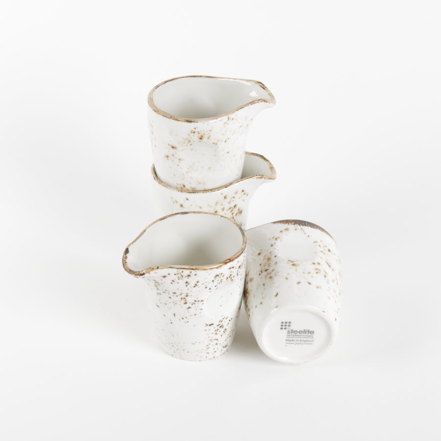 Set of four ceramic cups with speckled design on a white background