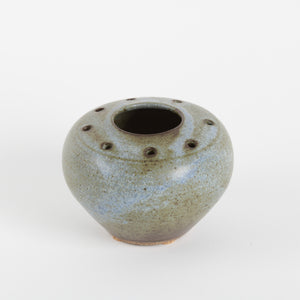 Small ceramic vase with textured surface on a white background