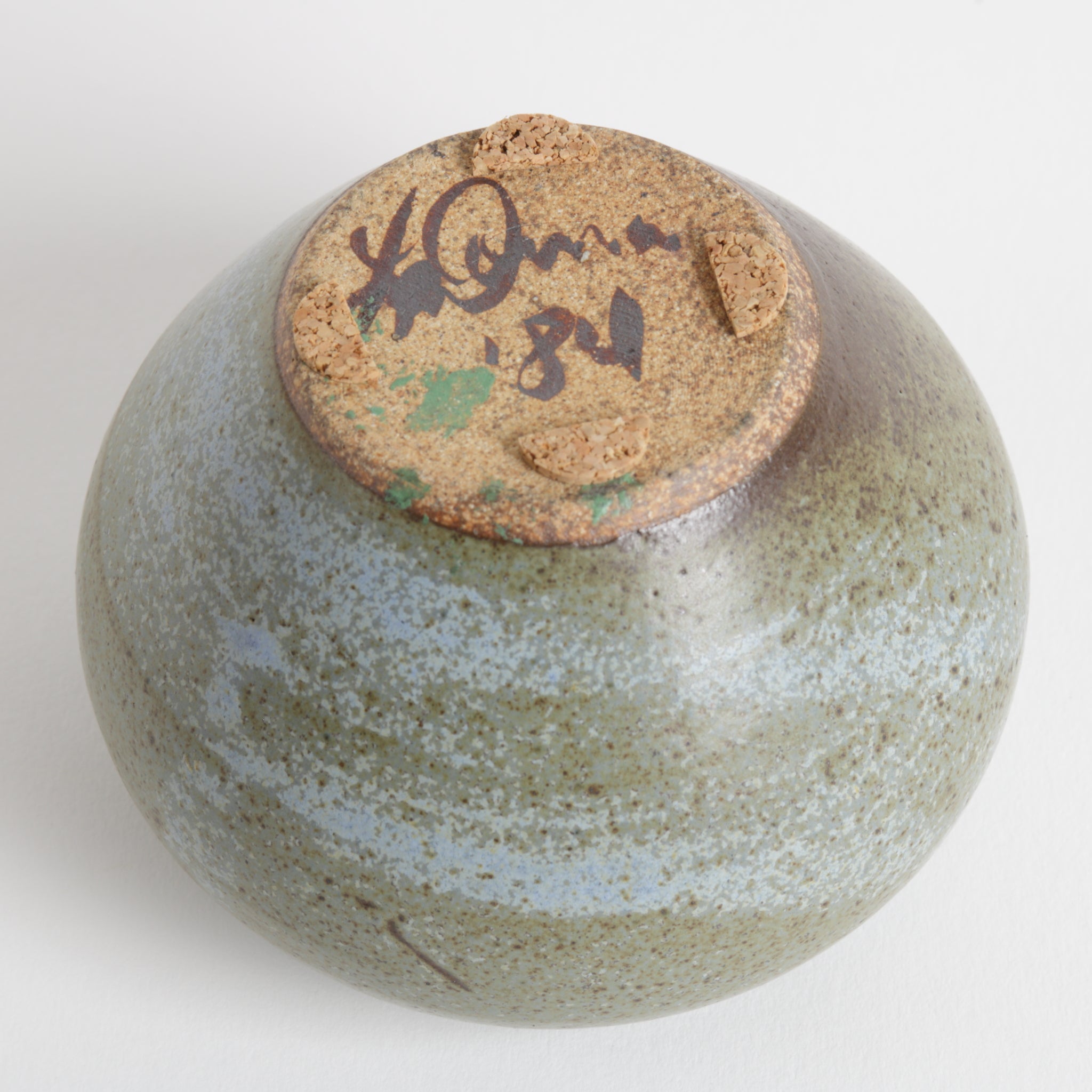 Ceramic bowl with a textured surface and a signature on a white background