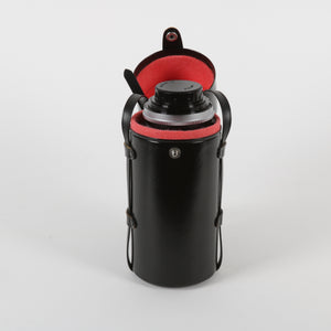 Tall black leather camera lens case with red interior holding a lens