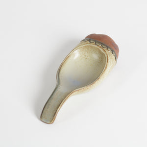 cream over terra cotta glaze on spoon rest with pig face
