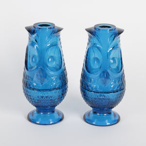 Two blue glass owl lanterns with textured design on a white background