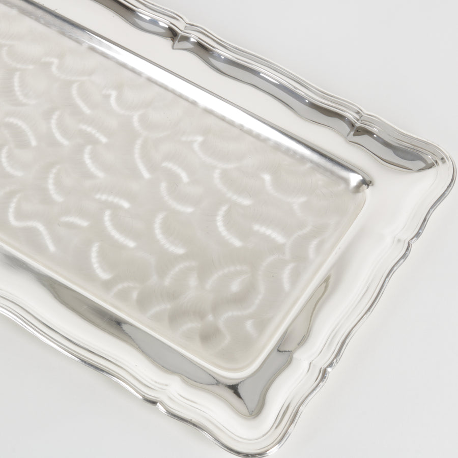 Silver rectangular tray with embossed design on a light gray background