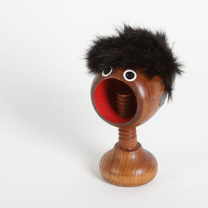 Wooden screw type nut cracker with a furry top and face and screw as a neck 