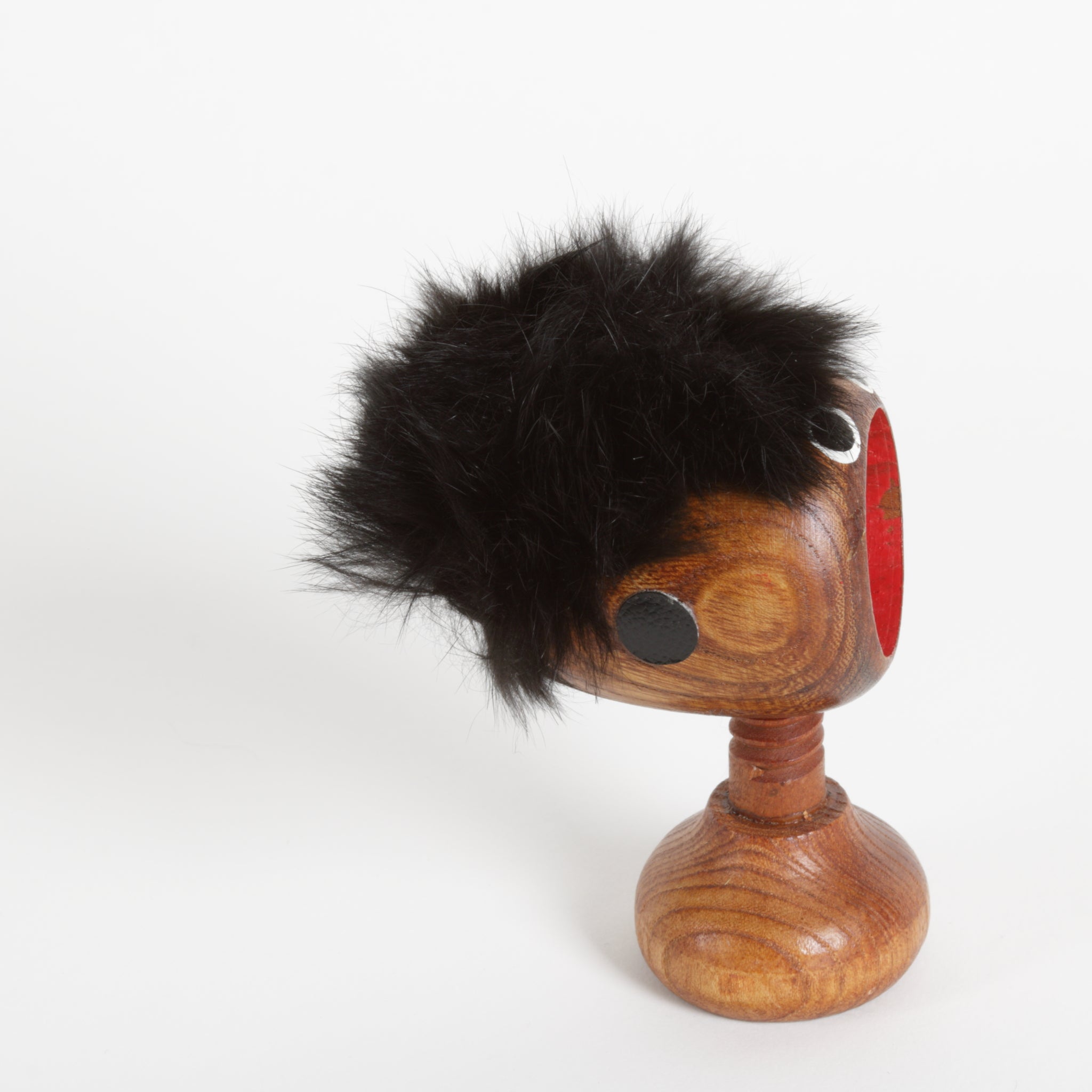Wooden screw type nut cracker with a furry top and face and screw as a neck 