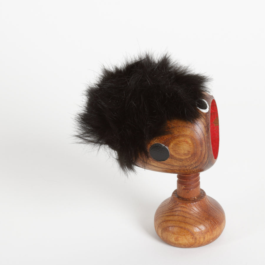 Wooden screw type nut cracker with a furry top and face and screw as a neck 