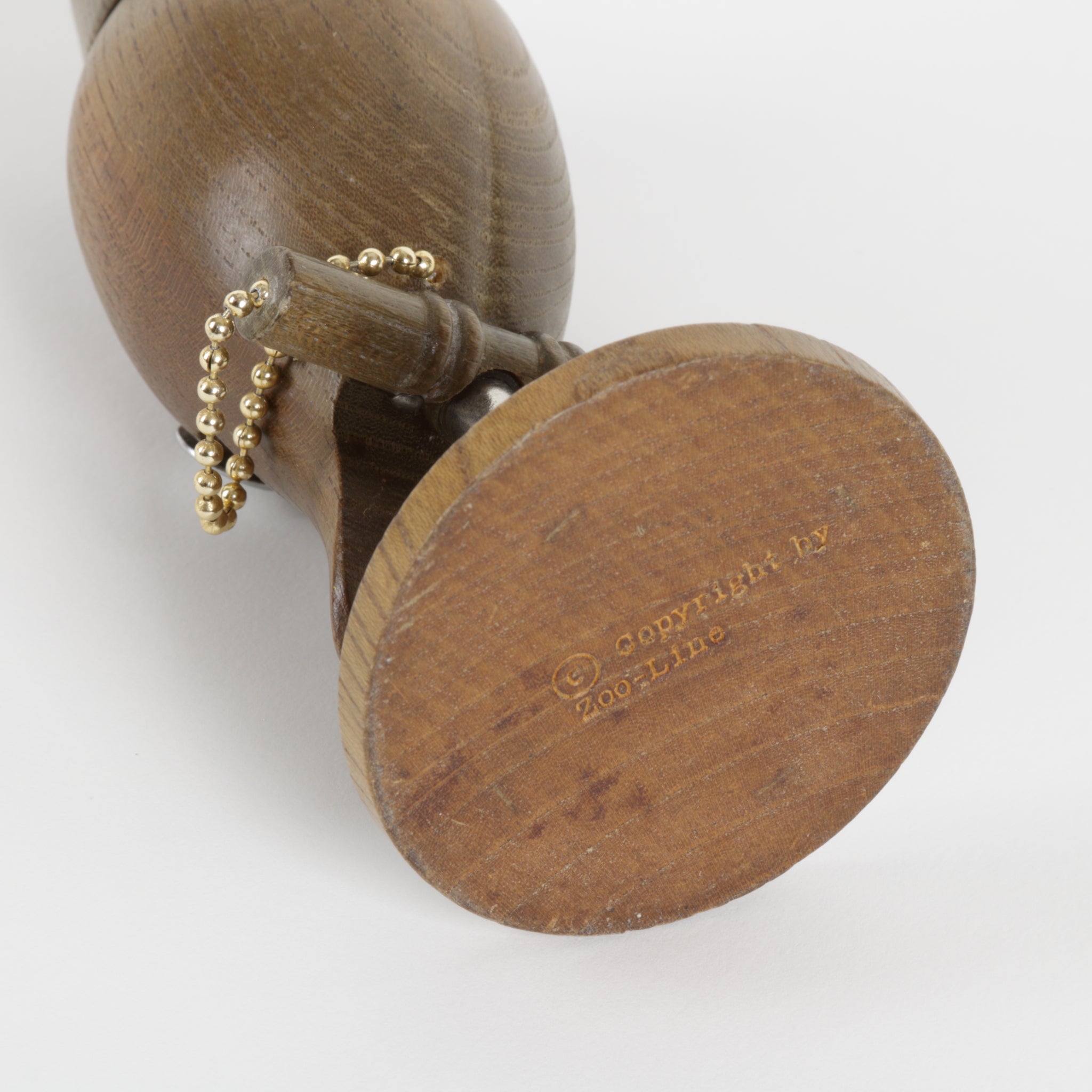 Wooden owl with a gold chain on a white background