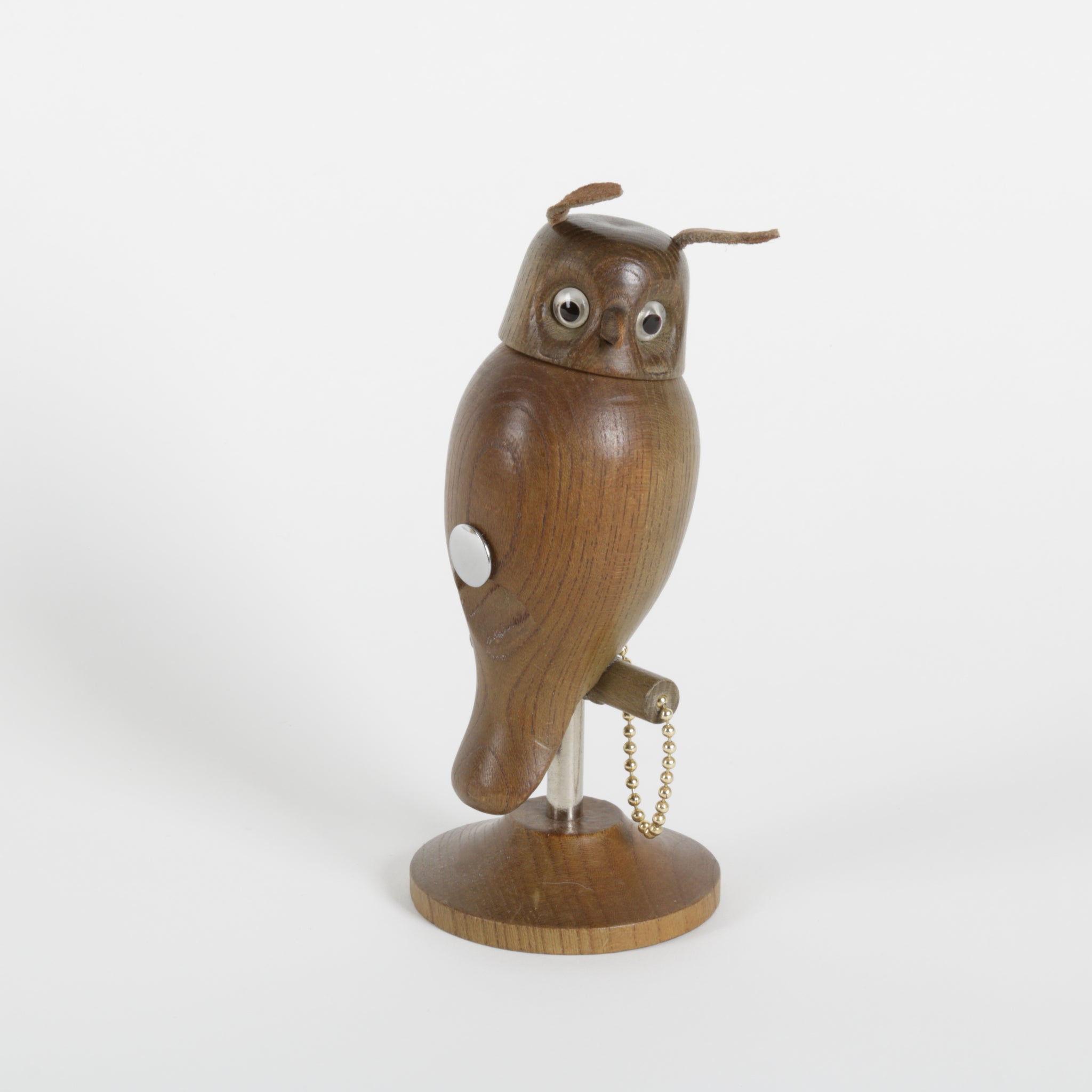 Wooden owl-shaped object with a chain on a white background