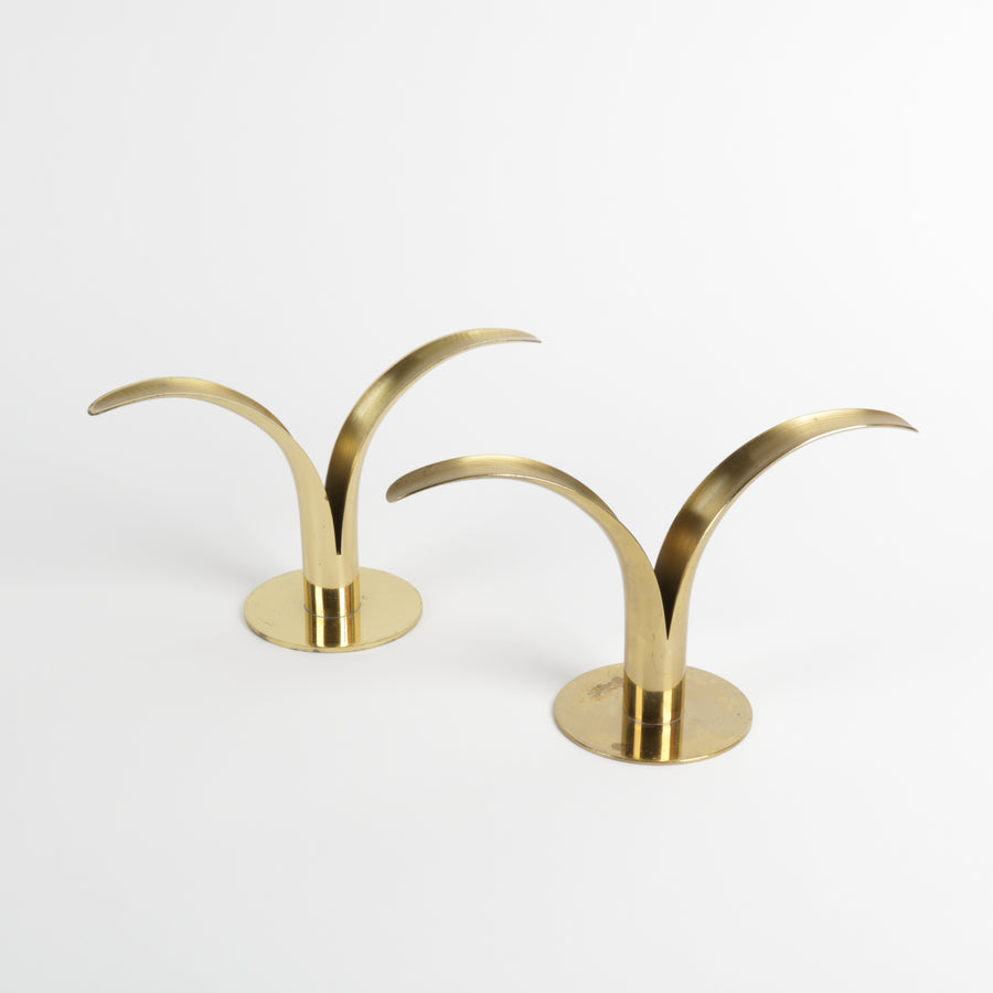 Two solid brass lily shaped candlesticks with long candles