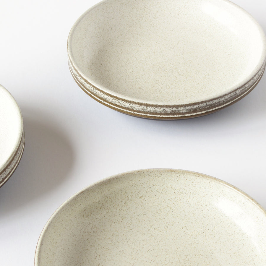 3 stoneware bowls cream in color with brown rims against a white background