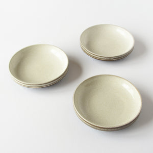 3 stoneware bowls cream in color with brown rims against a white background