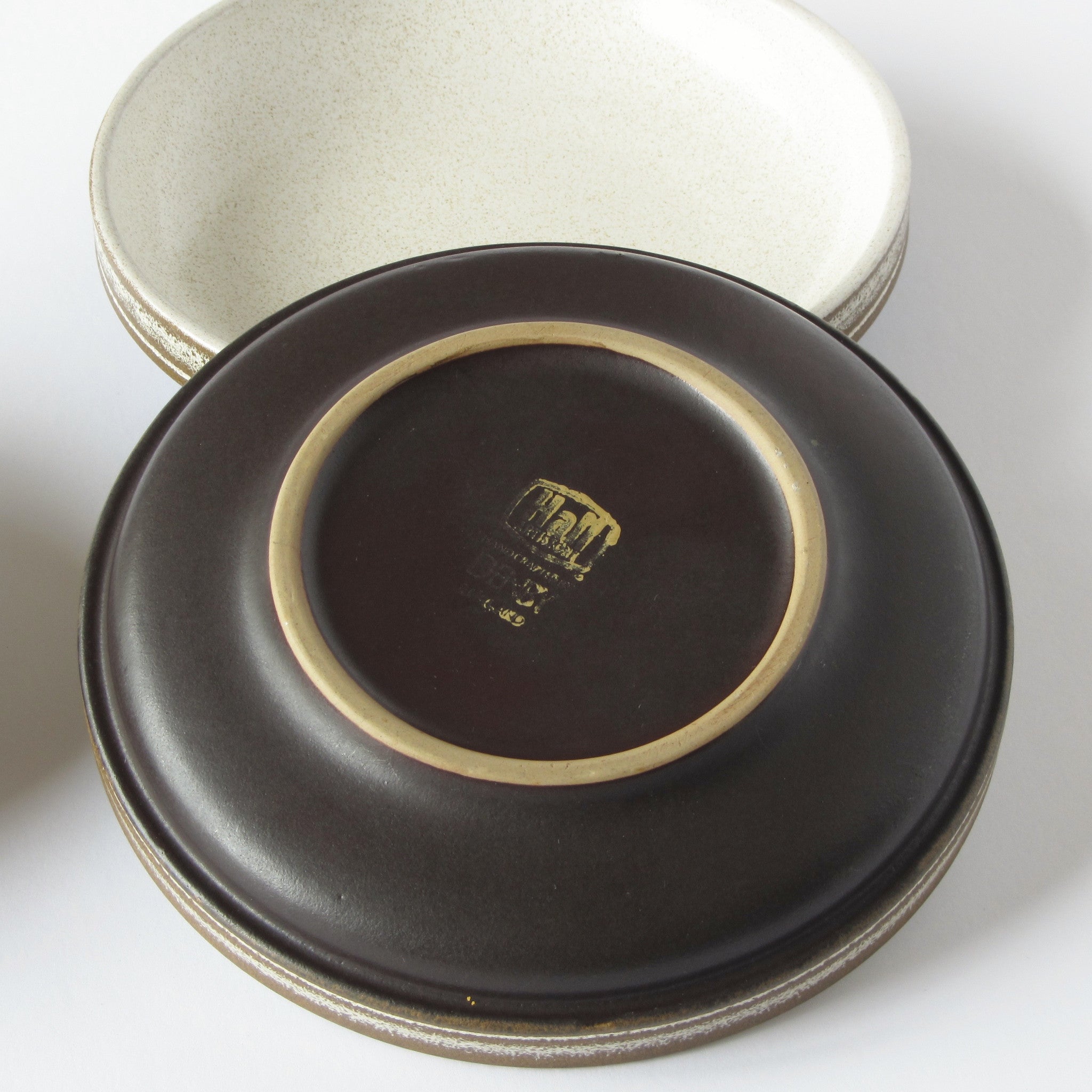 Manufacturers stamp 'Hall Artisan Denby' on bottom of brown and cream ceramic bowl
