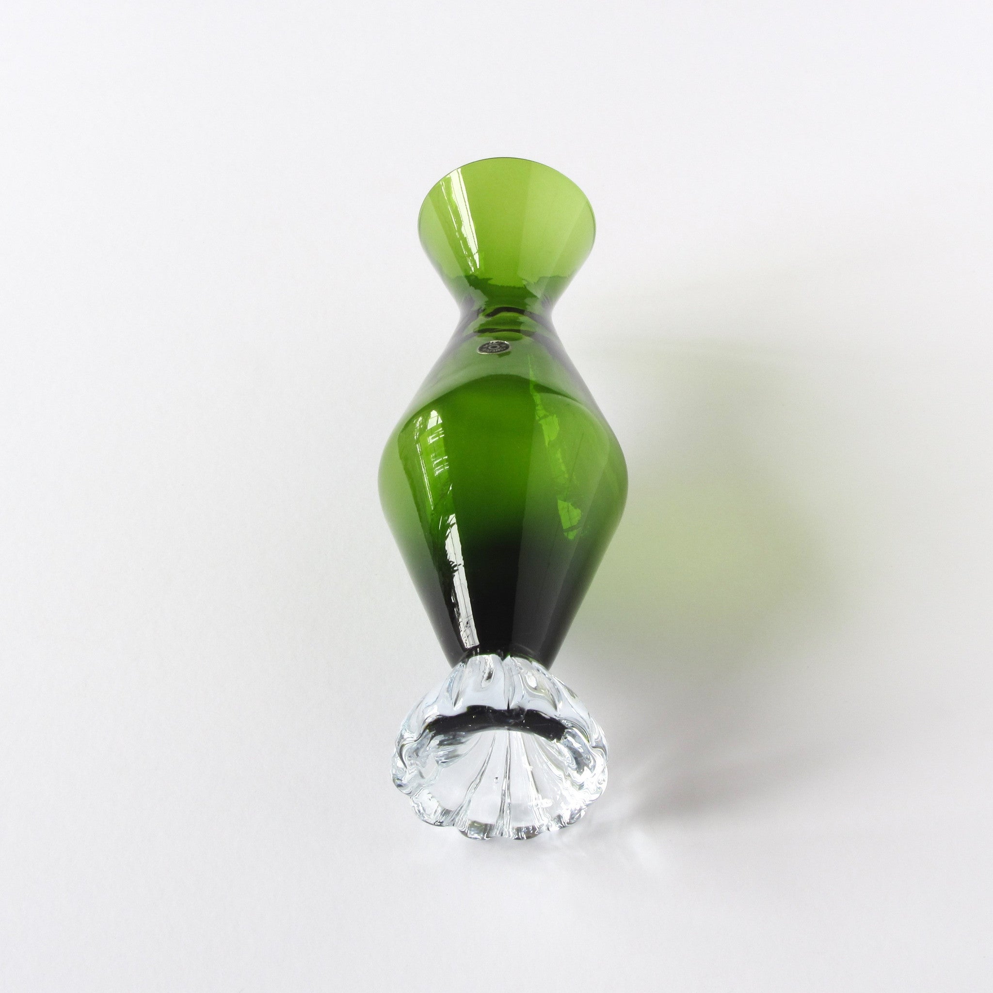 Green glass vase in hourglass shape with clear glass foot bottom